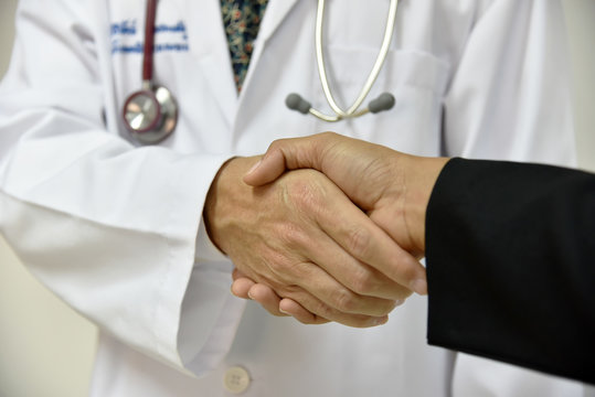 Male Doctor shaking a patient's hands;