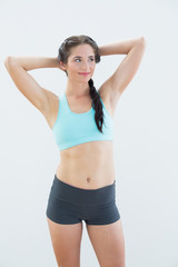 Fototapeta premium Fit young woman standing with hands behind head