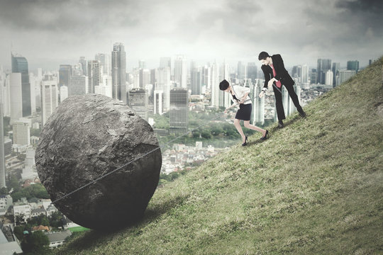 Business team pull rock with city background