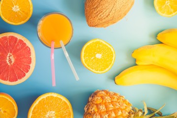 Colorful tropical and citrus fruits sliced over blue background