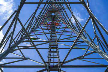 Telephone pole technology mobile telephone network base station telecommunication tower on blue sky background - bottom view