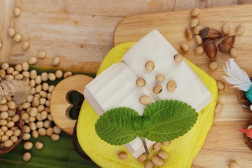 Tofu and soybean seed on wood background