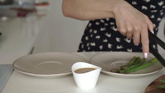 Female putting asparagus on a plate