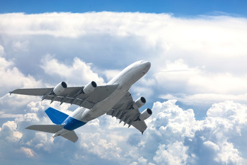 Fototapeta na wymiar Big four engine plane on the sky with clouds. Aircraft on long intercontinental flights.