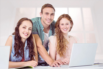 Fashion students using laptop against bright white room with windows