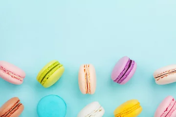  Macaron of macaroon op turquoise pastel achtergrond van bovenaf. Kleurrijke amandelkoekjes op dessert bovenaanzicht. © juliasudnitskaya