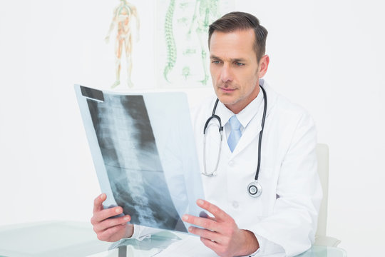 Concentrated male doctor looking at xray picture