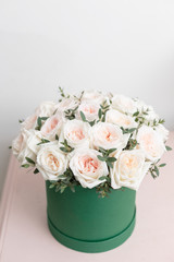 White and pink roses. Bouquet of beautiful flowers on wooden table. Floristry concept. Spring colors. the work of the florist at a flower shop. Vertical photo