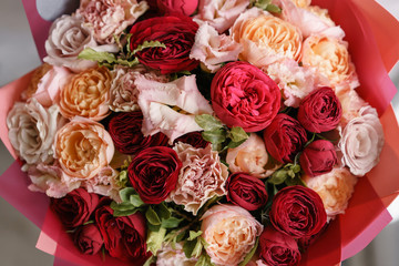 Multicolor bouquet of beautiful flowers on wooden table. Floristry concept. Spring colors. the work of the florist at a flower shop. Vertical photo