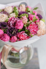 purple and pink bouquet of beautiful flowers on wooden table. Floristry concept. Spring colors. the work of the florist at a flower shop. Vertical photo