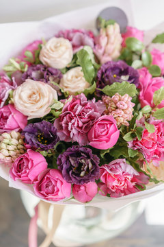 purple and pink bouquet of beautiful flowers on wooden table. Floristry concept. Spring colors. the work of the florist at a flower shop. Vertical photo
