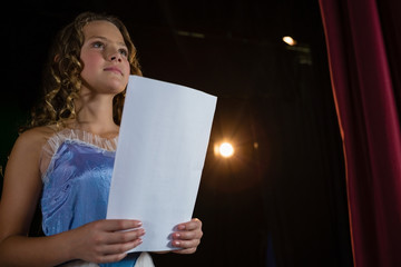 Female artist reading her scripts on stage