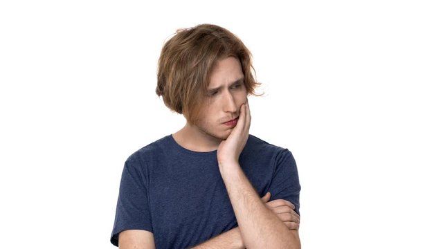 Portrait of focused hairy guy in basic t-shirt with brooding look thinking hard or reflecting about idea, over white background. Concept of emotions
