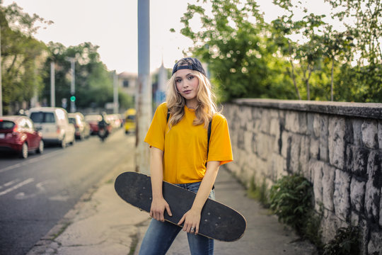 Pretty girl holding a skateboard