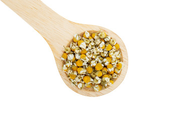 Dried chamomile flowers and wooden spoon isolated on white background, top view.