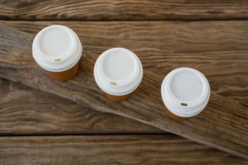 Disposable coffee cups on wooden plank