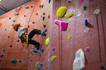 Determined boy practicing rock climbing