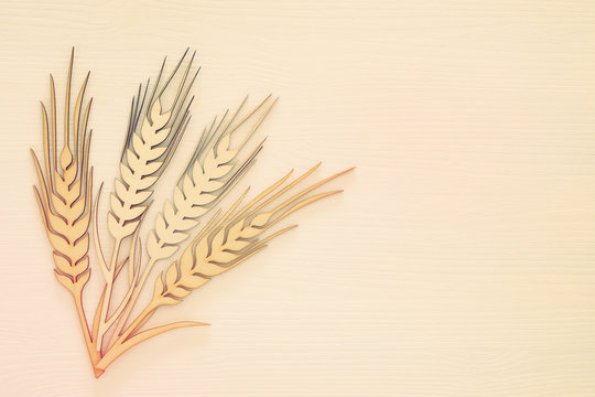 top view of wooden wheat crop decoration over white background. Symbols of jewish holiday - Shavuot.
