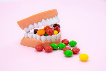Plastic teeth and dental model with colorful candy, Dental care concept