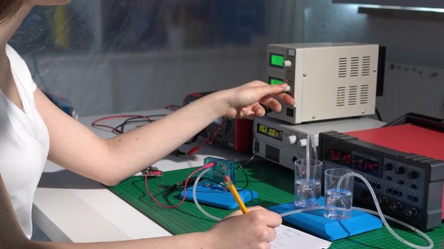 Young girl student in physical lab with hydrogen power cell