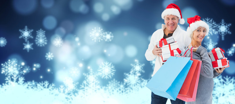 Couple With Shopping Bags And Gifts Against Snowflake On Blue Background