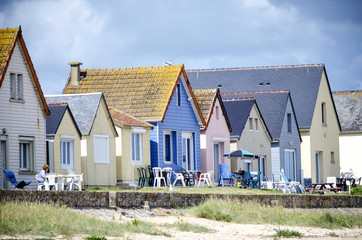 Normandy, Gran Hameau des Dunes. Row of colorful houses on the beach. Cotentin. Normandy. France.