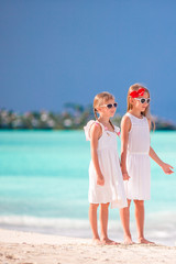 Little happy kids have a lot of fun at tropical beach playing together