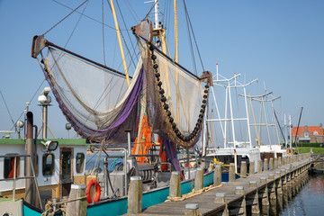 Harbor dutch fishing village Makkum with shrimp trawler drying nets at beautiful summer day