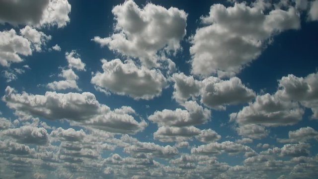Time lapse clouds travel across a blue sky.
