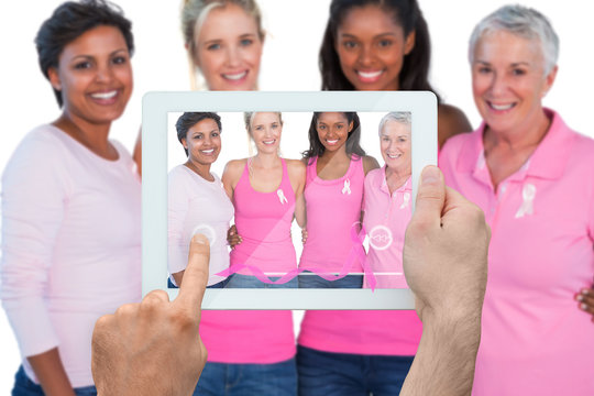 Composite image of hand holding device showing photograph of breast cancer activists