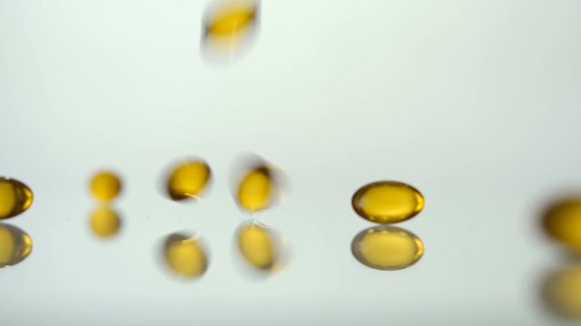 Medical pills scatter on a white background.Yellow pills. Slow motion. Pills background