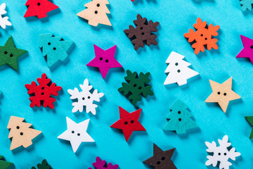 Christmas buttons carved out of wood on a blue background. Christmas trees, snowflakes, stars - obrazy, fototapety, plakaty