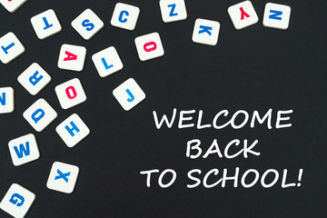 english colored square letters scattered on black background with text welcome back to school - Powered by Adobe