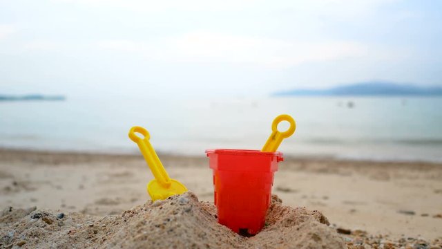 Toys on the sand beach with sea wave select focus shallow depth of field with summer evening atmosphere