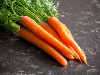 fresh carrots bunch on rustic stone background.