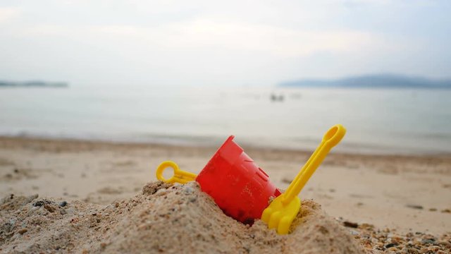 Toys on the sand beach with sea wave select focus shallow depth of field with summer evening atmosphere