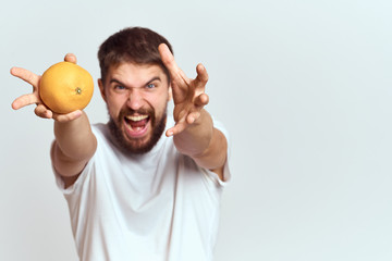 aggressive man stretched out his hands to the camera and an orange in his hand
