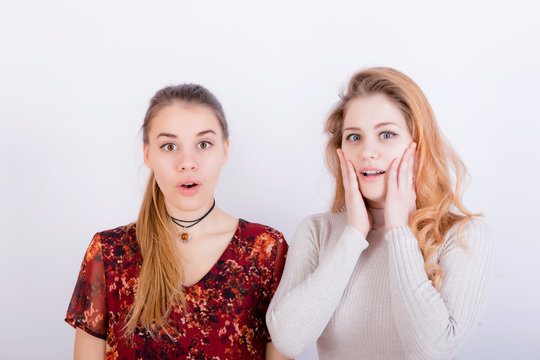Two young beautiful girls look very surprised