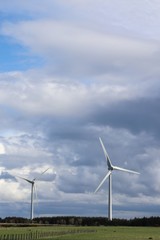 Wind tturbines against blue sky with fluffy white clouds