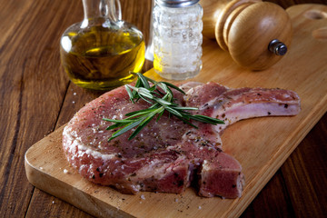 raw pork chop steak on wooden background.