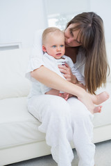 Baby sitting on his mother knees