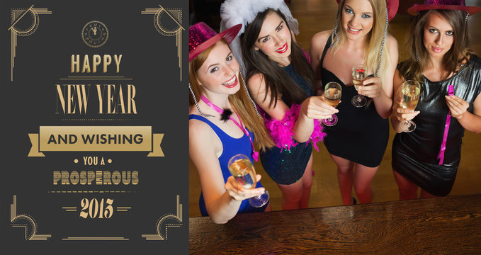 Happy gorgeous women holding flutes of champagne having hen party against art deco new year greeting