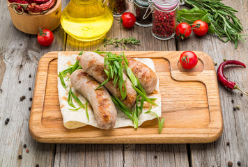 grilled sausages on the grill on the board
