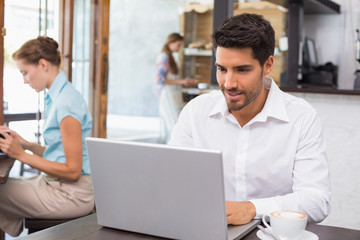Man using laptop in coffee shop