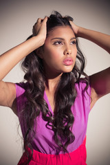 Fototapeta premium Seductive attractive brunette posing for camera ruffling her hair