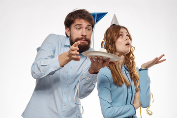 a man with a cake and a woman in a cap looks up