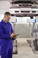 Concentrated mechanic holding a clipboard