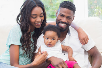 Happy couple with their baby girl on couch