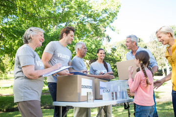 Happy volunteer family separating donations stuffs