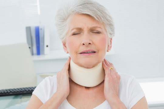 Senior Woman Wearing Cervical Collar In Medical Office